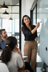 Professional presenting ideas on a glass board to colleagues